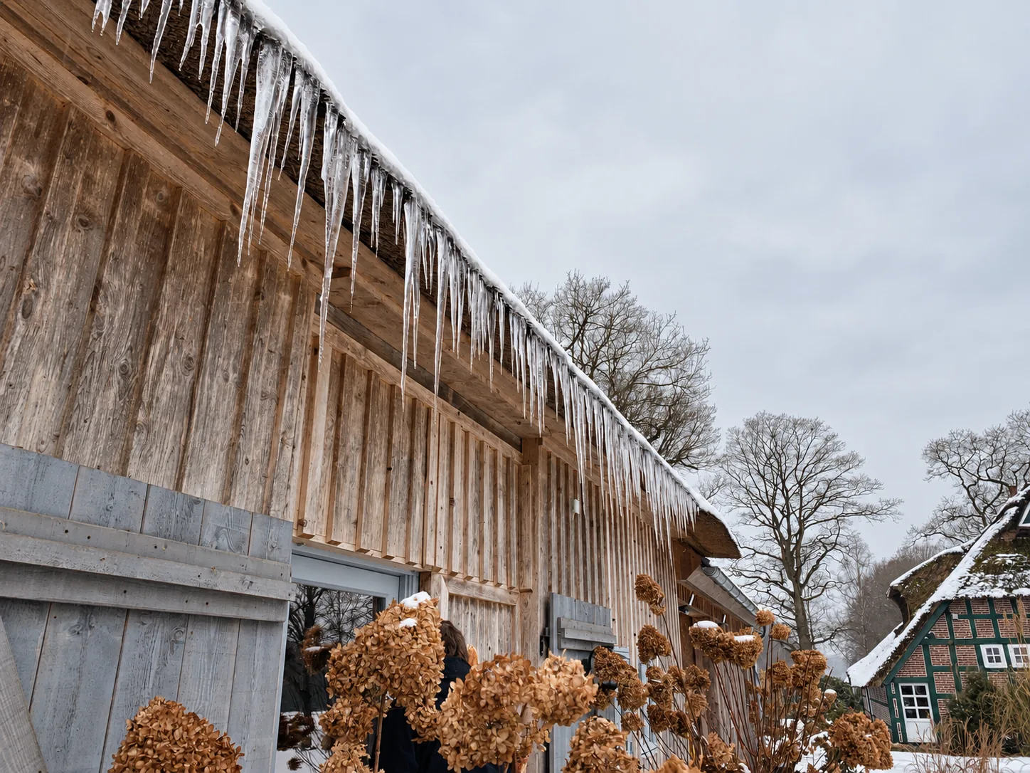 Eiszapfen am Dach eines Holzhauses