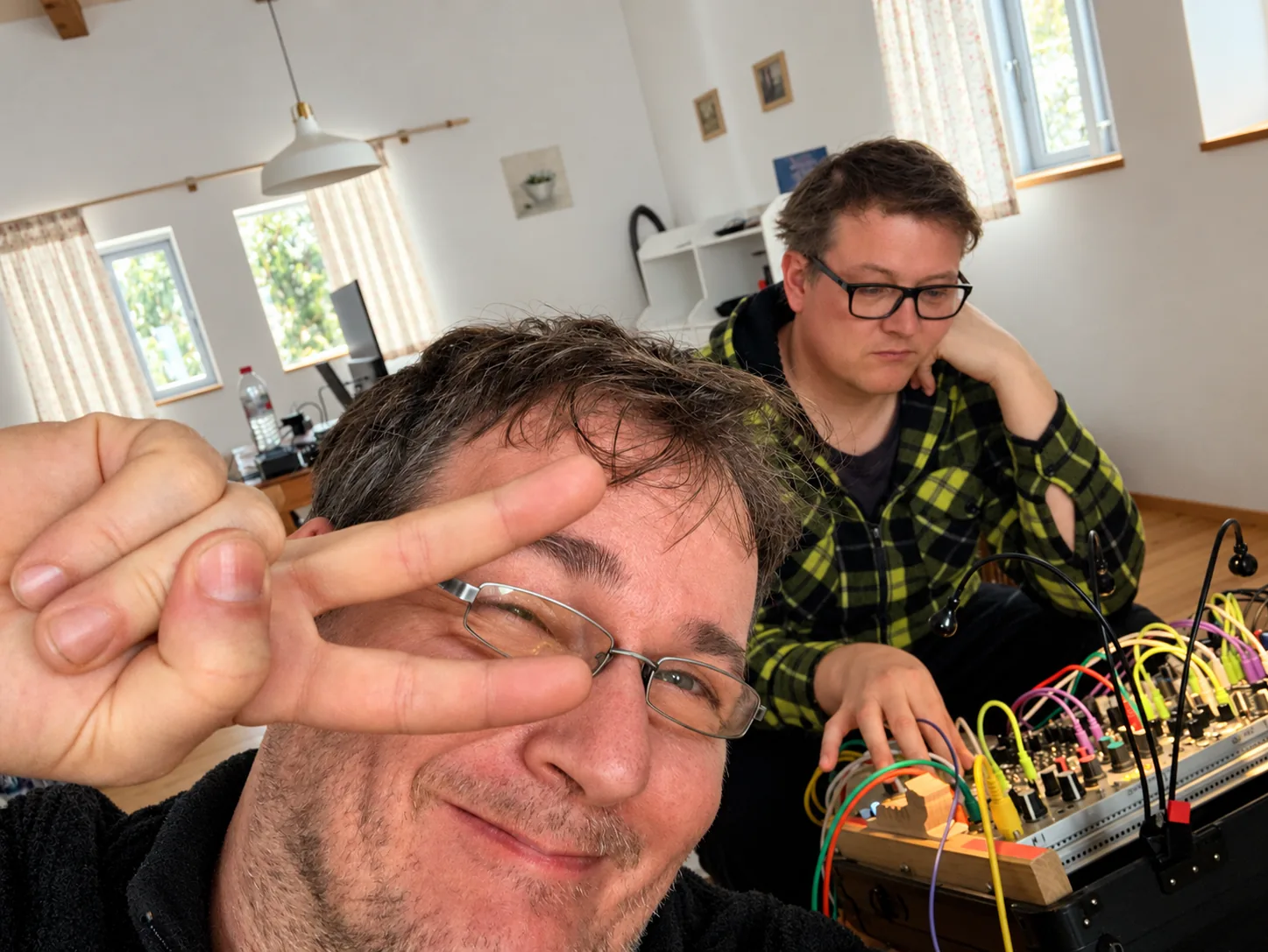 Peace-Zeichen und konzentriertes Arbeiten am Synthesizer